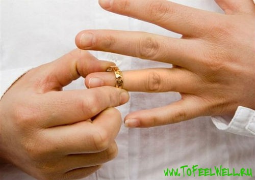 снимает золотое кольцо с пальца