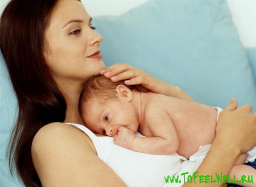 женщина держит младенца на руках