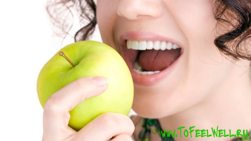 девушка кусает зеленое яблоко