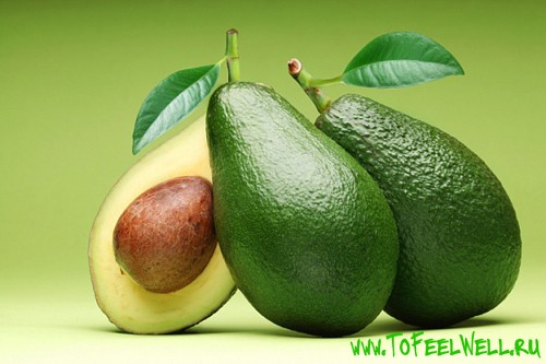 авокадо с косточкой на зеленом фоне